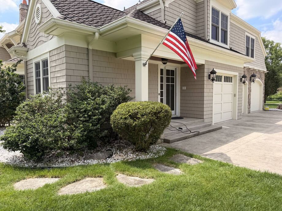 Craftsman home with manicured beds and stepping stone path