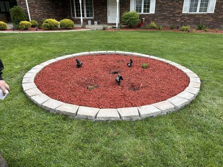 Mulch bed with fresh plantings at brick home